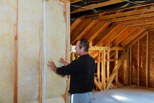 Worker thermally insulating a house attic using mineral wool in greenwich CT